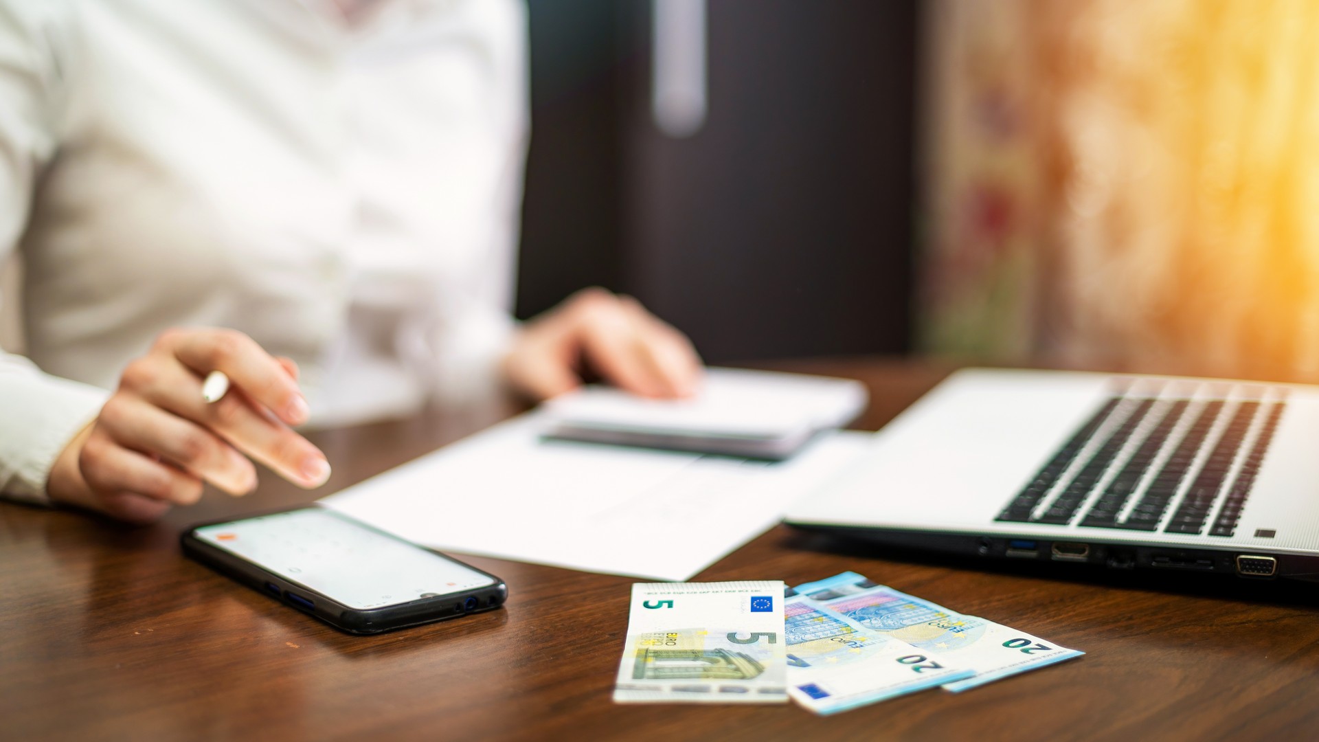 Przedsiębiorca analizujący limit zwolnienia z VAT w 2026 roku – praca przy laptopie, dokumenty, kalkulacje finansowe